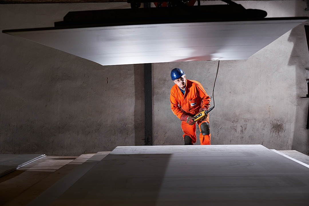 Industrial photography: steel sheet lifting with electro-magnetic crane handling, steel stock, Stoke-On-Trent UK
